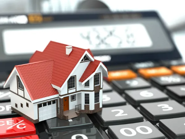 A model house sitting on a calculator